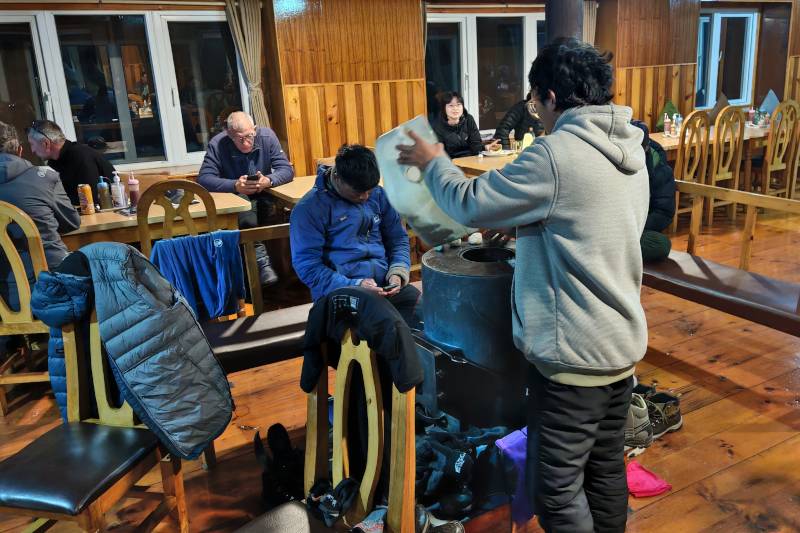 Adding yak dung as fuel to the heater in the dining room.