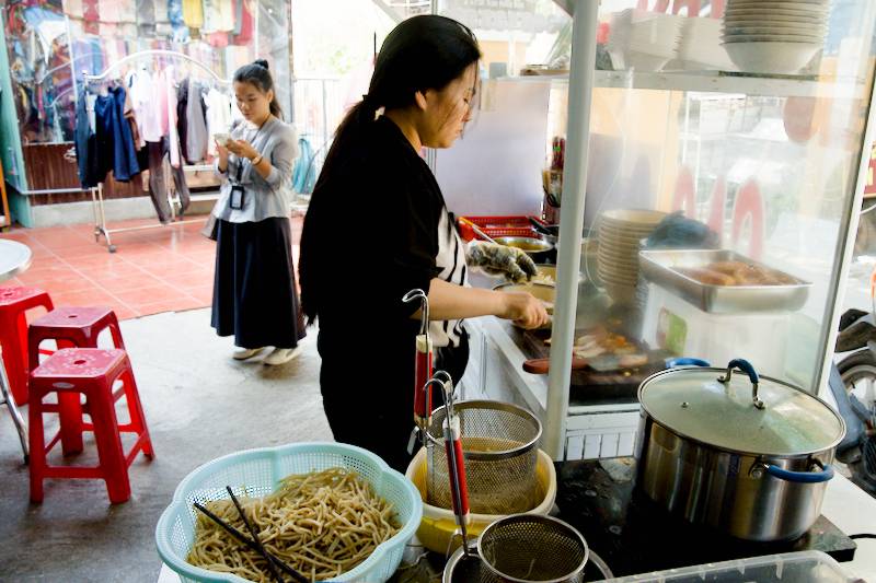 The lady is cooking Cao Lầu, a famous noodle dish from central Vietnam, Da Nang
