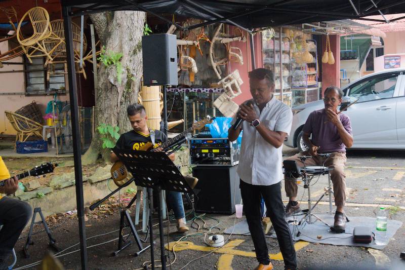 A group of senior locals had gathered beside the stall, singing and playing music.